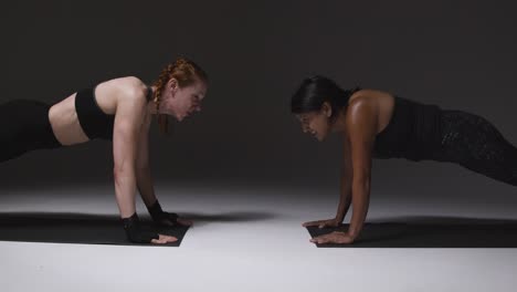 Studioaufnahme-Von-Zwei-Reifen-Frauen-In-Fitnesskleidung,-Die-Gemeinsam-Plankenübungen-Machen-2